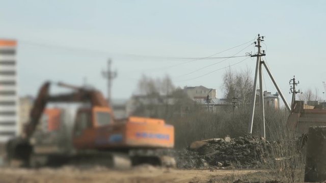 Excavator uploads a clay in a truck using a bucket