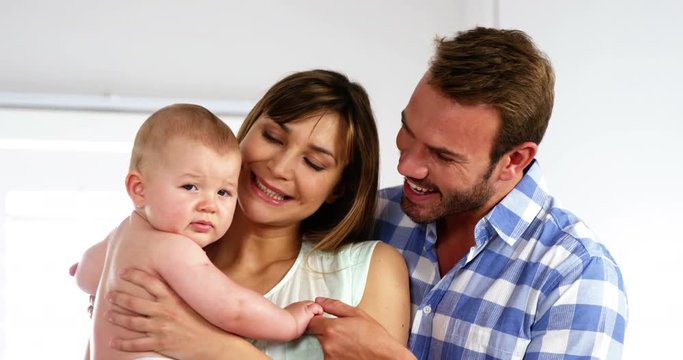 Happy father and daughter holding their baby