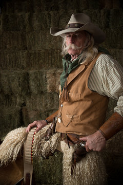 Old western cowboy with wooly chaps and pistols
