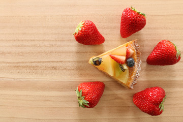 fruit cake and strawberry on wooden texture