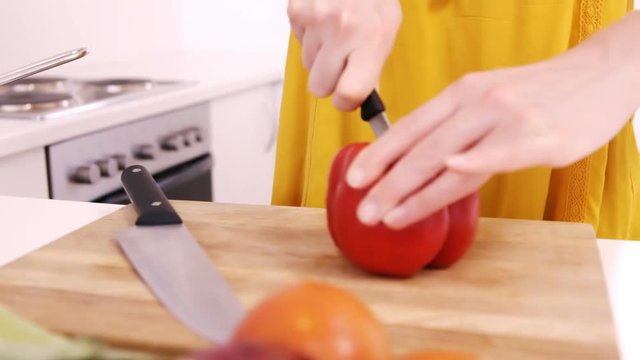 Close up on a woman carving sweet pepper 