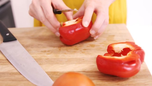 Close up on a woman carving sweet pepper 