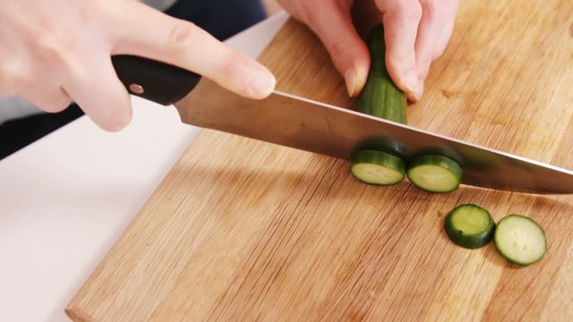 Close up on a woman carving a cucumber 