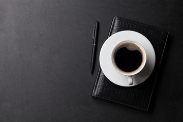 Office desk with coffee, notepad and pen