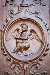 Angel engraved on the wooden portal of an ancient church.