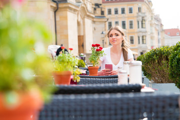 Woman drinking cappuccino at an outdoor cafe