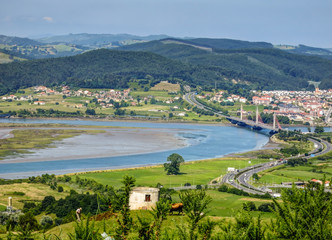 Fototapeta na wymiar Cantabria landscape with field, river and a small town Treto. Spain.