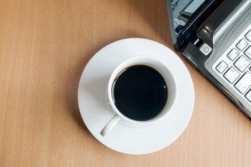 Top view of Laptop and coffee cup on office wooden background
