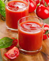 Tomato juice and ripe tomatoes  on  a wooden table