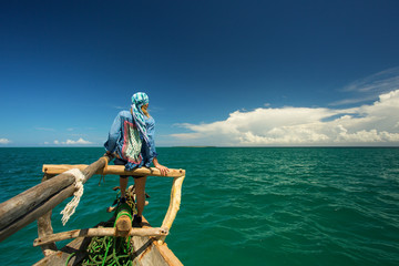 Woman enjoying time on the traditional fisher boat in Zanzibar - obrazy, fototapety, plakaty