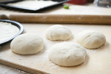 Fototapeta na wymiar ball of pizza dough with flour on a table