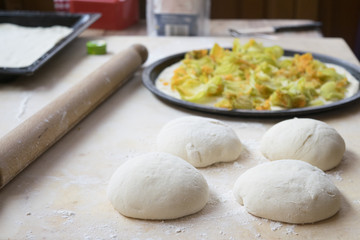 balls of pizza dough with flour on a table