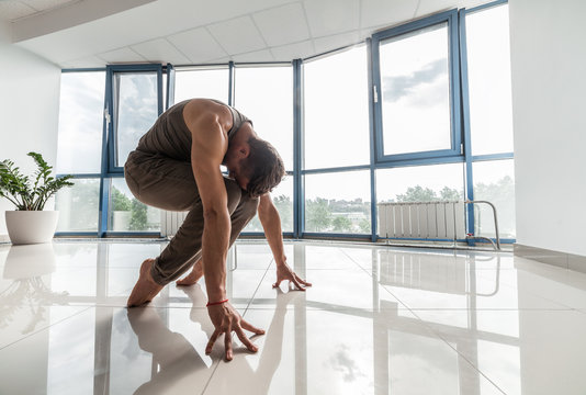 Man training yoga at the gym