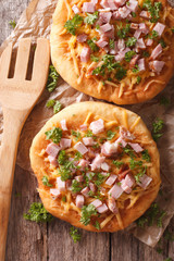 Hungarian pancakes langos with ham and cheese on the table. Vertical top view
