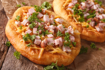Hungarian Food: langos with ham and cheese close-up. horizontal

