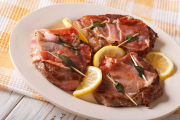 Italian Saltimbocca veal with sage, ham and lemon. horizontal
