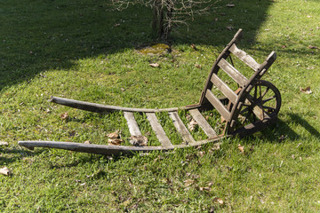 old wooden wheelbarrow on grass