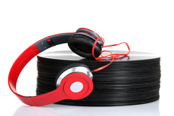 full sized headphones near a pile of stacked vinyl records isolated on white background