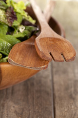 wooden utensils on a bowl of vegetable's salad