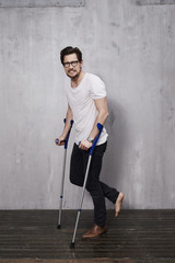 Anxious young man on crutches in studio