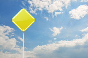 Yellow warning blank road sign over the blue cloudy sky