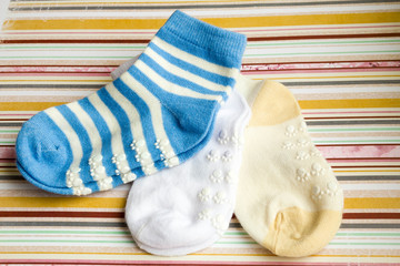 Kids bright background with three baby socks with copy space for Your message