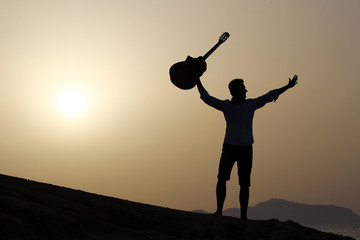 joyful guitarist with guitar up in the air