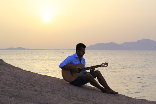 musician on the beach playing guitar