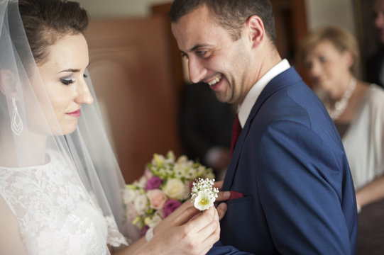 Przypinanie butonierki ślubnej z kwiat&oacute;w panu młodemu