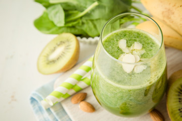 Green smoothie and ingredients on white background