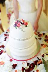Layered wedding cake decorated with pearls and roses