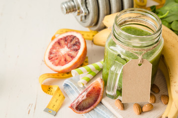 Green smoothie and ingredients on white background