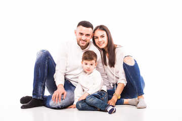 happy family mother, father and son sitting on the floor on white