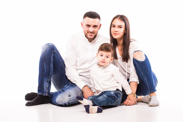 happy family mother, father and son sitting on the floor on white