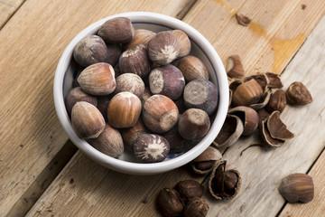 Close-up of hazelnuts on wooden table. Some broken, shelled, some whole