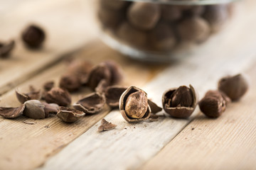 Close-up of hazelnuts on wooden table. Some broken, shelled, some whole