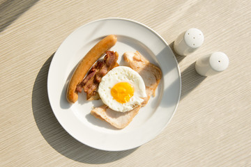 Breakfast set eggs, ham, sausage with morning light.