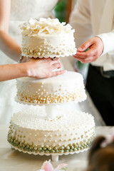 A beautiful wedding cake decorated with green and white pearls