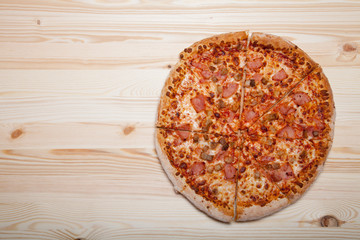 Fresh homemade pizza on light wooden table