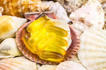 Fatty acid, omega 3 capsules on the beautiful seashells background