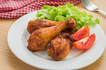 Grilled chicken legs and vegetables on plate