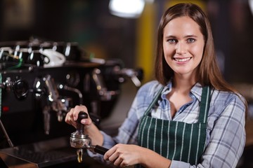 Smiling barista preparing coffee with machine