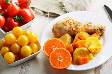 chicken drumstick cooked in spices with vegetables in the plate