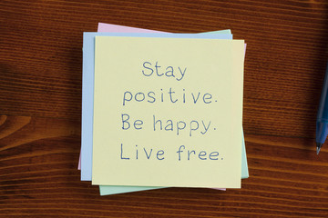 Stay positive Be happy Live free handwritten on note