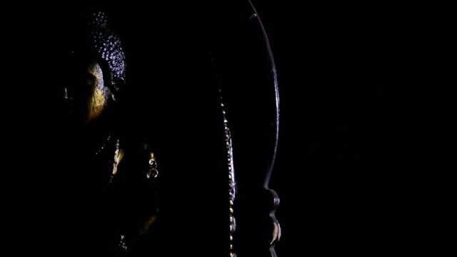 Buddha praying figure rotating at black background