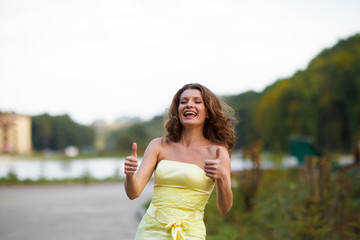 Naklejka premium Woman smiles holding her tumbs up