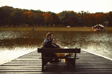 Man and woman rest on the bench at the lake