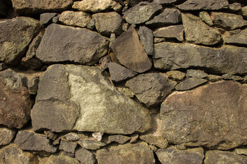 Background wall of stones wet after rain