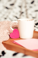 Cup of tea staying on wooden tray in room. Good morning.