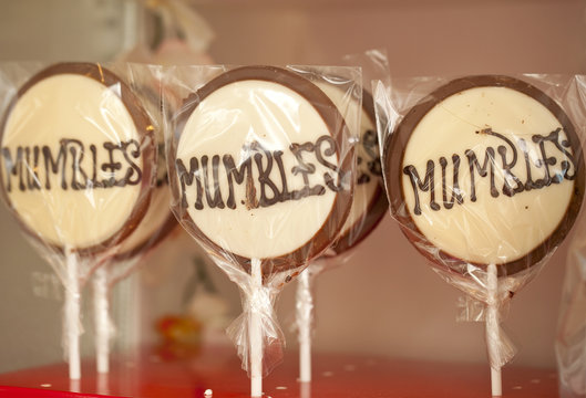 Mumbles. Chocolate lollypops with the word Mumbles repeated. The Mumbles is an area on the east side of the Gower Peninsular that is commuting distance to Swansea in Wales.